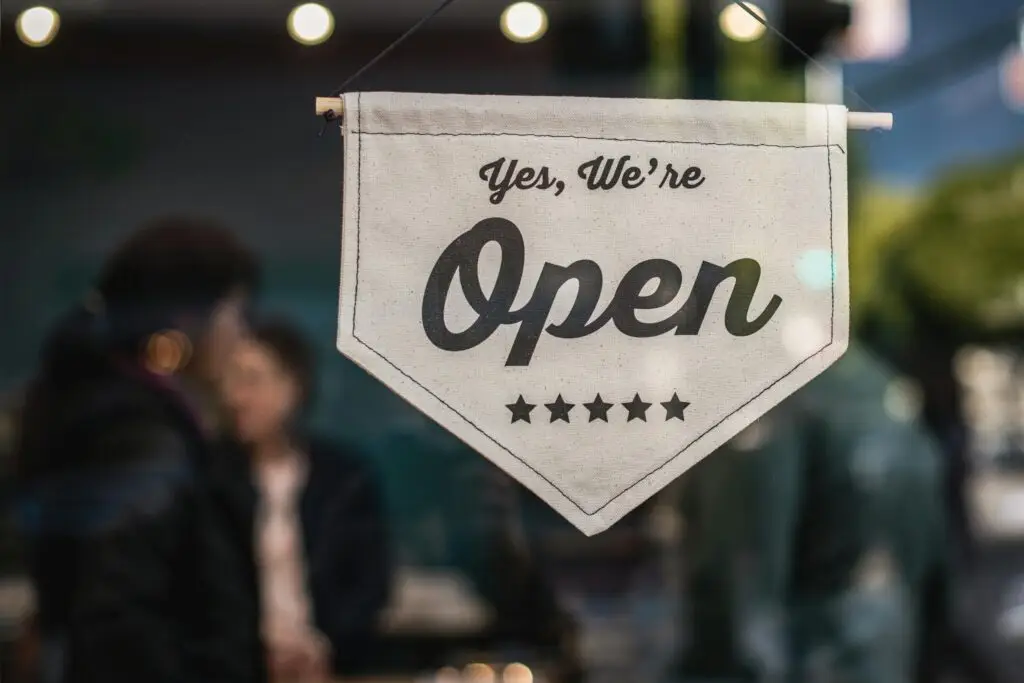 A hanging sign reads "Yes, We're Open" with five stars below the text.
