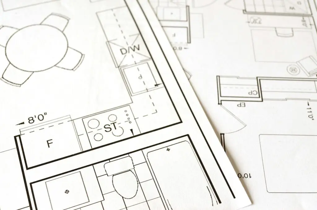 Close-up of architectural floor plan drawings with visible room layouts and furniture symbols.